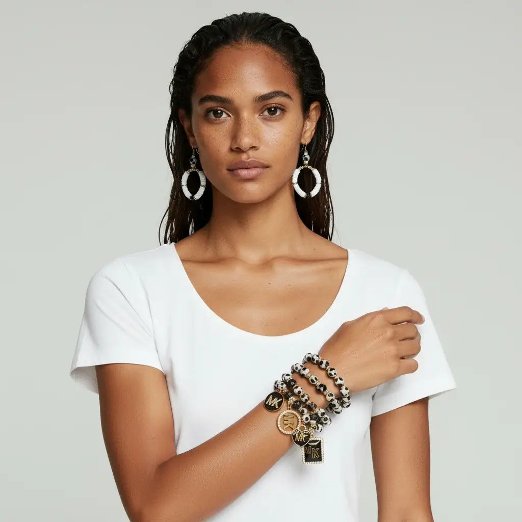 Model wearing the Legacy Ebony Ivory Duo Gem Set bracelet and earrings, showcasing chic black-and-white design with gold accents.