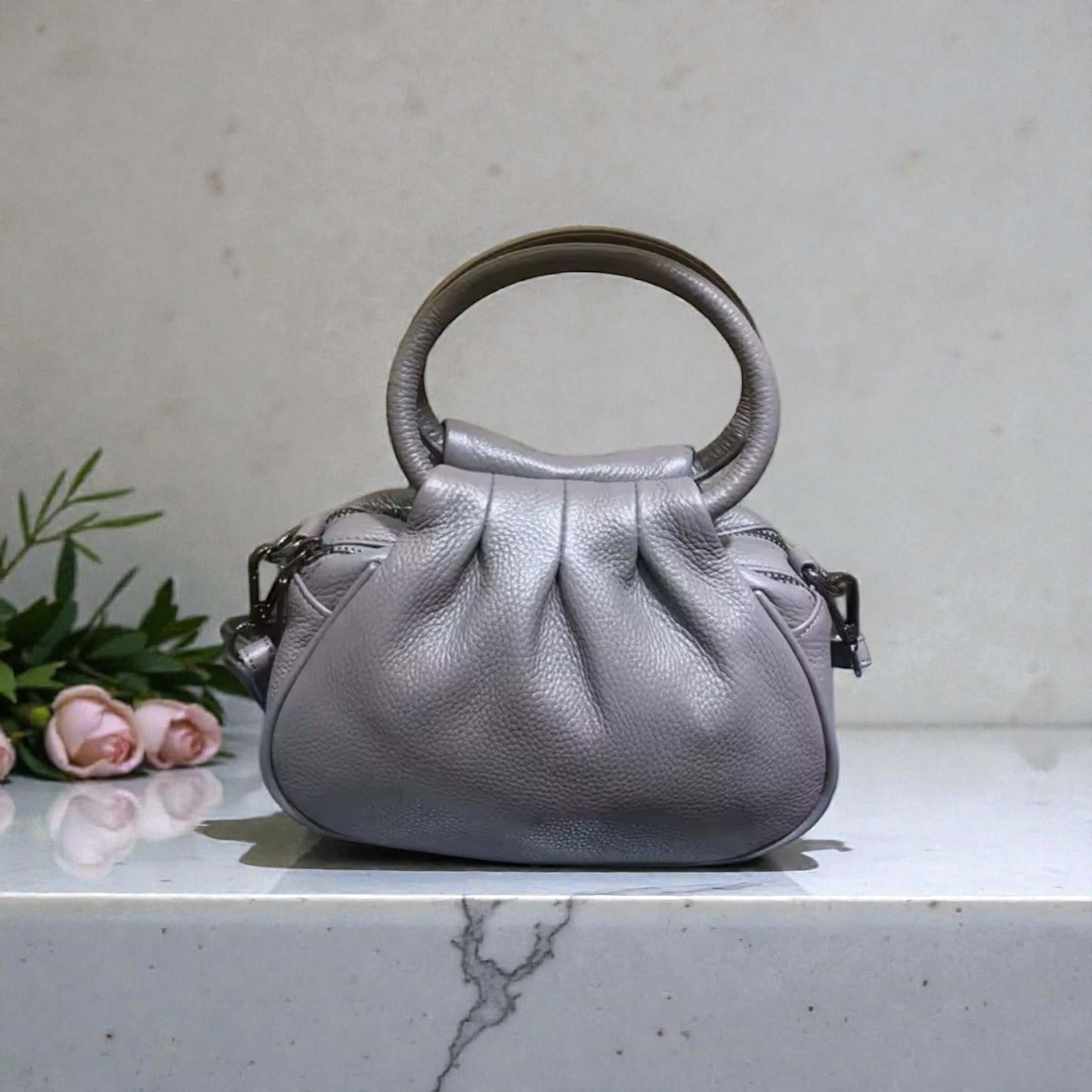 Silver Cloud Mini Carry, a chic gray handbag with a pleated silhouette and rounded top handles.