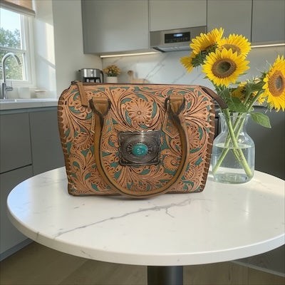 Legacy Dealz tan leather satchel with intricate Western tooling, turquoise accents, and silver concho with turquoise stone.