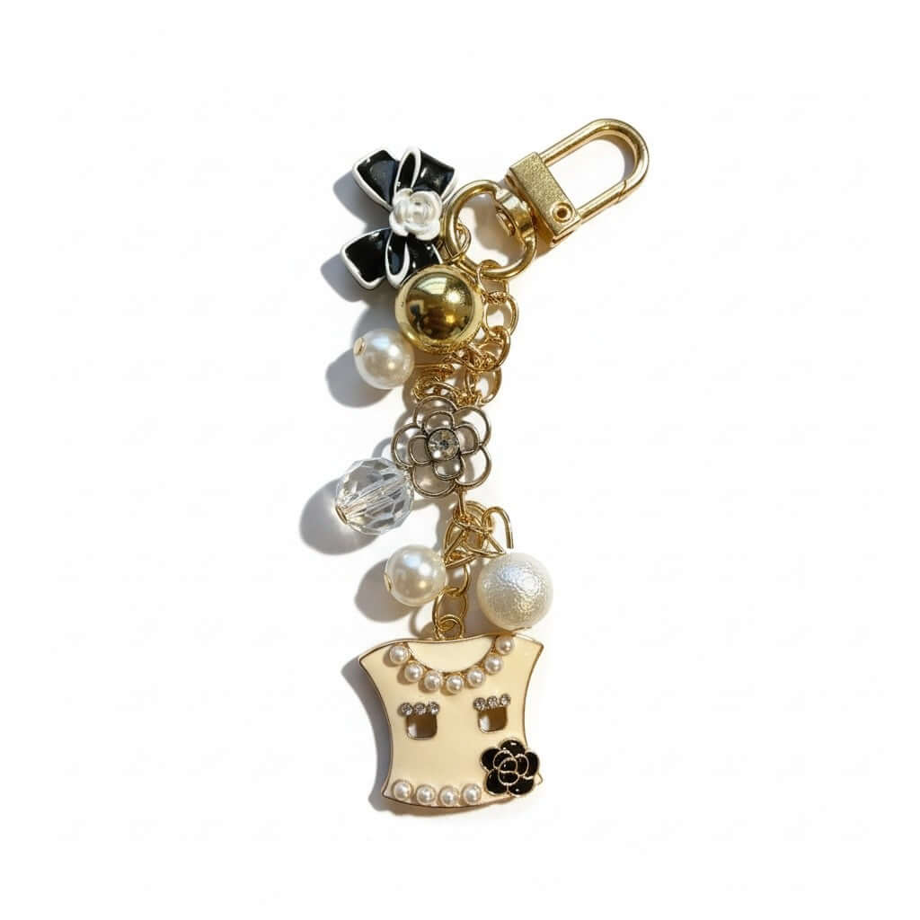 Legacy Pearl Couture Charm featuring pearls, crystal accents, black bow, and gold details for stylish handbags.