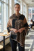Legacy Luxe Wild Harmony Shawl – Animal Print Wrap with Cashmere-Like Feel displayed in a stylish cafe.