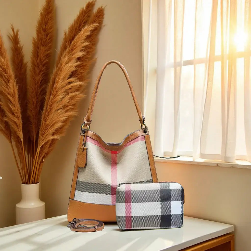 Plaid Bucket Bag & Pouch Set on a table with warm lighting and decorative plants in the background.