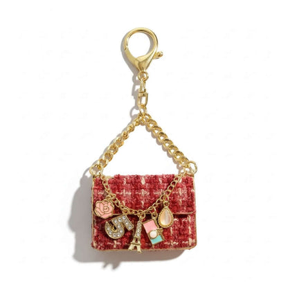 Legacy Parisian Charm Mini features luxe tweed-style with gold chain, charms like Eiffel Tower, rose, and sparkling initial.