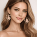 ✨ Blush Legacy Heart Earrings – One of One worn by a model, showcasing elegant gold-tone frame and blush heart drop.