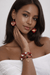 Crimson Heirloom Heart Jewelry Set – One of One worn by a model showcasing heart earrings and a multi-strand bracelet.