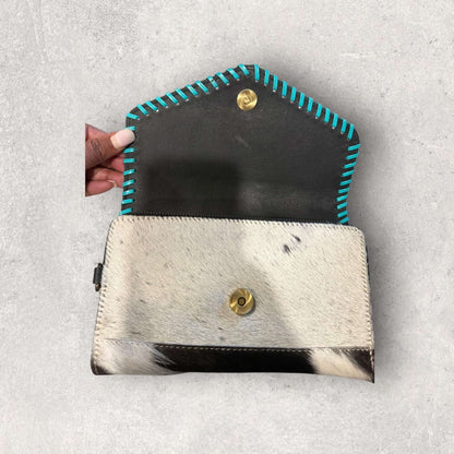 Interior view of the Saddle Bloom Cowhide Crossbody Wallet with turquoise whipstitch detailing and unique cowhide texture.