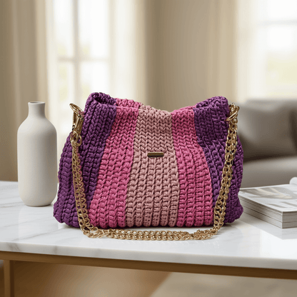 Seraphine Rose-Plum Crochet Bag displayed on a table with soft hues of plum and rose, featuring a stylish metal chain strap.