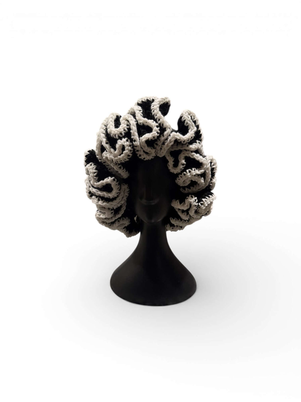 Monochrome Ruffle Crown-Signature Texture Crown displayed on a black mannequin with dramatic ruffle detailing.