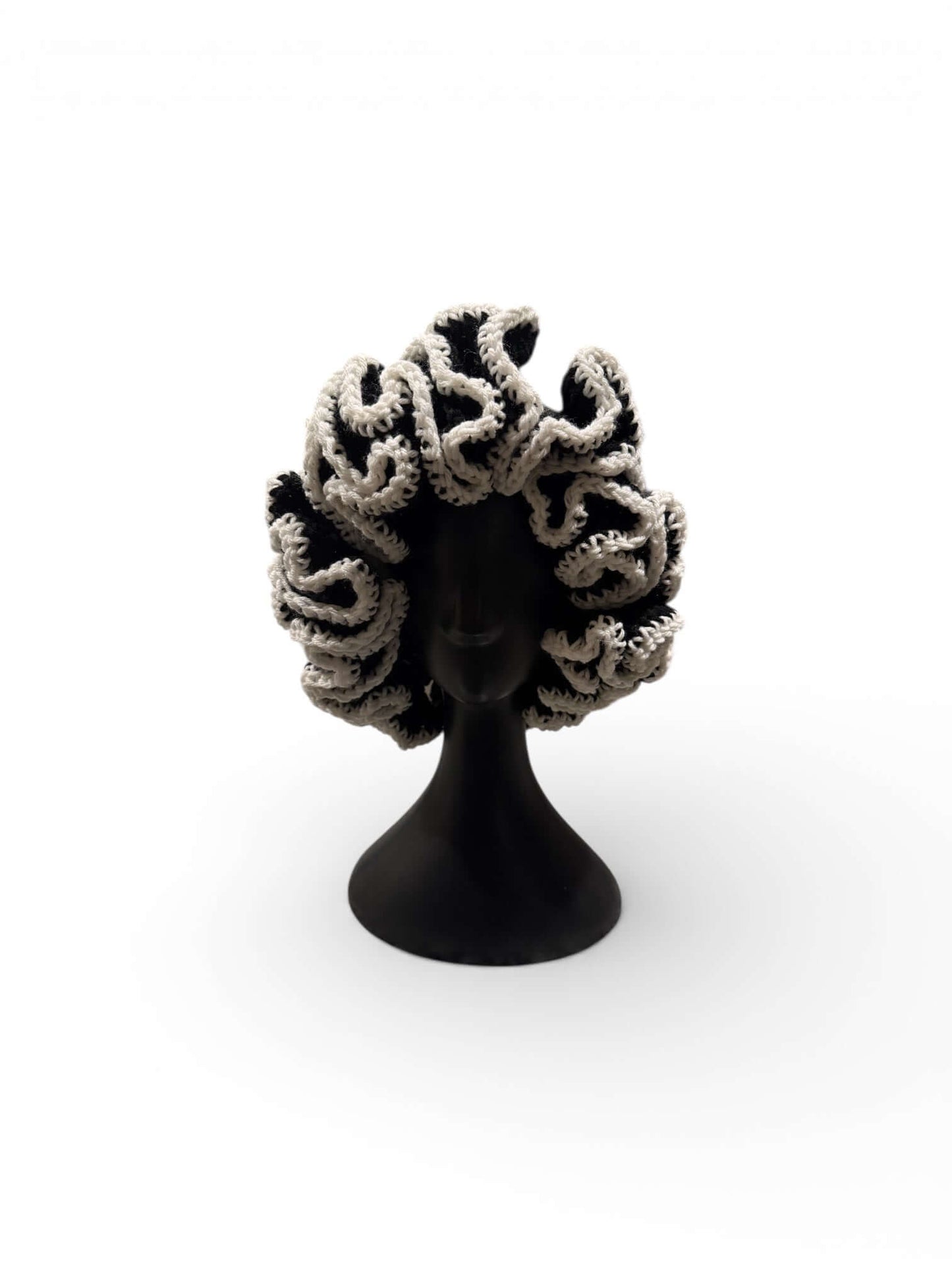 Monochrome Ruffle Crown-Signature Texture Crown displayed on a black mannequin with dramatic ruffle detailing.