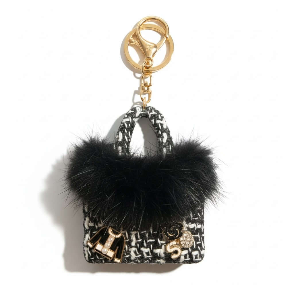 Legacy Noir Luxe Mini Charm with plush black faux fur and gold enamel charms on a stylish keychain.
