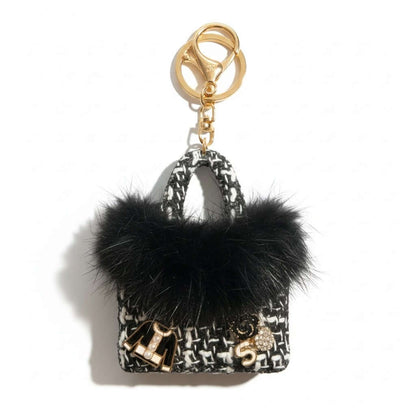 Legacy Noir Luxe Mini Charm with plush black faux fur and gold enamel charms on a stylish keychain.