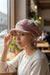 Signature Texture Crown Set- Blush Heirloom – Handcrafted One-of-a-Kind model wearing a crochet cap and earrings in a café.
