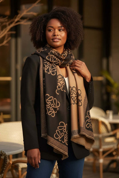Woman wearing the Legacy Luxe Signature Monogram Shawl – Brown or Black styled with a blazer in an outdoor setting.
