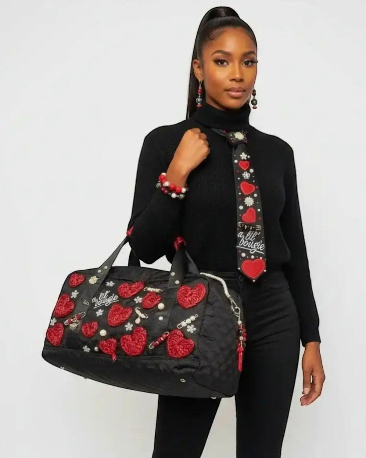 Legacy Dealz black quilted duffel bag with red heart appliques, pearls, and sparkling accents. Matching tie with hearts and script.