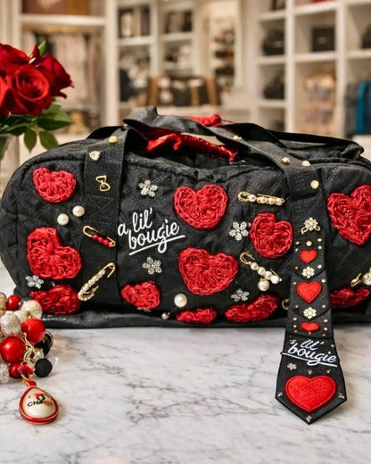 Legacy Dealz black quilted duffel bag with red heart appliques, pearls, and sparkling accents. Matching tie included.