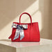 Legacy Dealz red pebbled leather tote bag with scarf accent on handle. Structured, spacious, and stylish.